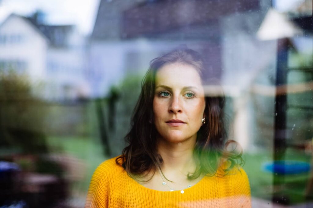 A sad girl looking out the window after moving internationally