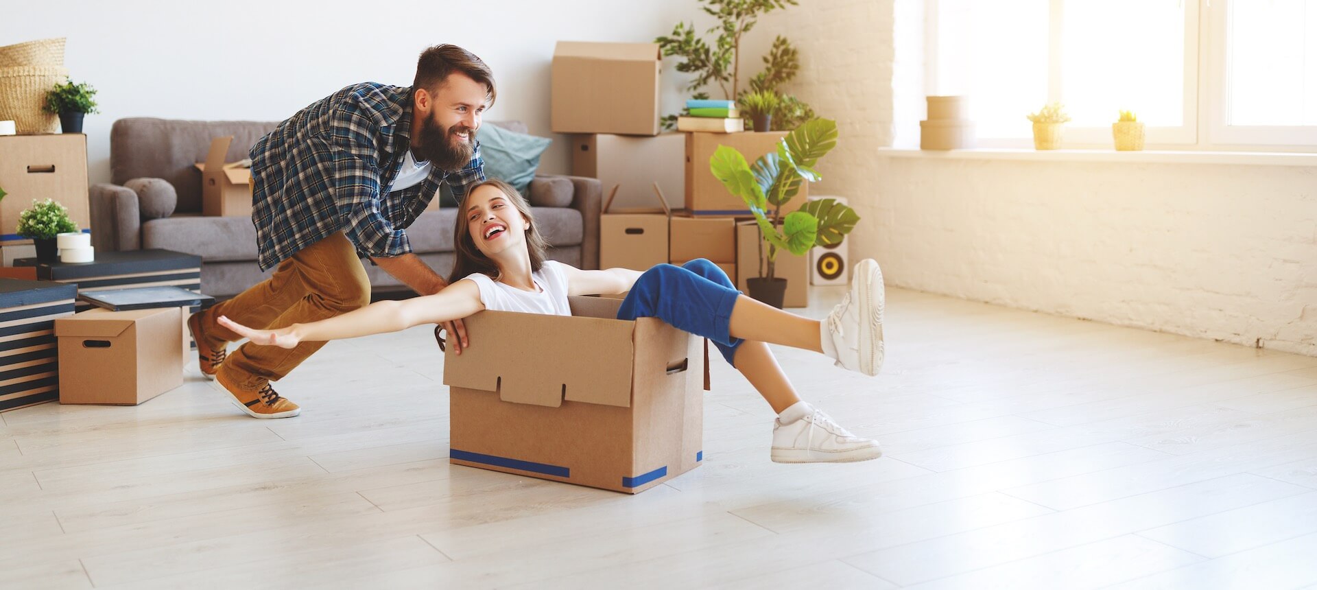 Man pushing a woman across the room in a box before moving overseas